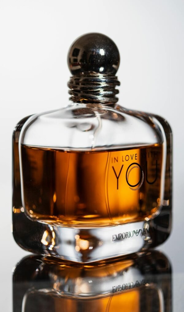 Close-up of luxury perfume bottle on glass surface with elegant curvature.