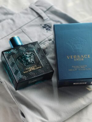 Versace Eros perfume bottle and box displayed on stylish light fabric, capturing luxury.