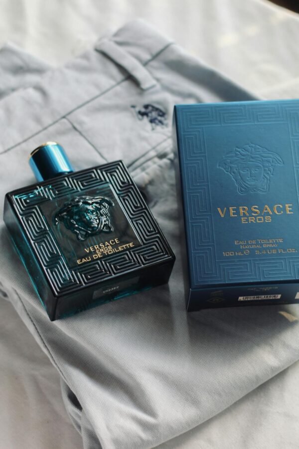 Versace Eros perfume bottle and box displayed on stylish light fabric, capturing luxury.